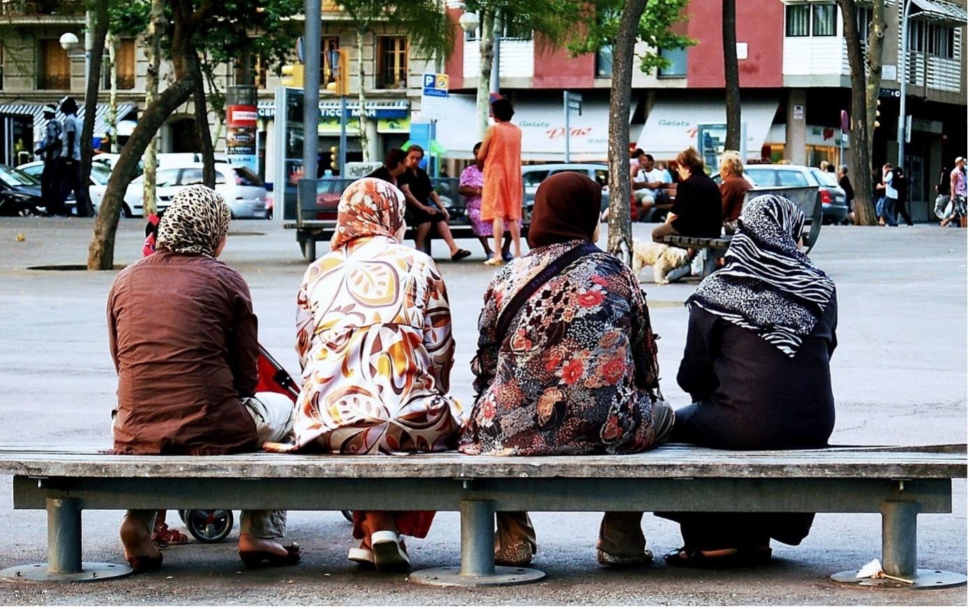 Vier Frauen muslimischen Glaubens sitzen auf einer Bank